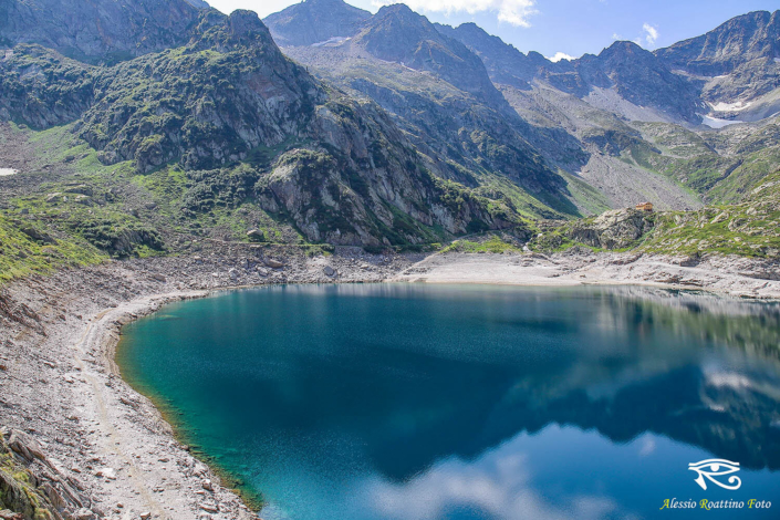 Entracque, lago del Chiotas con le montagne sullo sfondo e il cielo riflessi sull'acqua